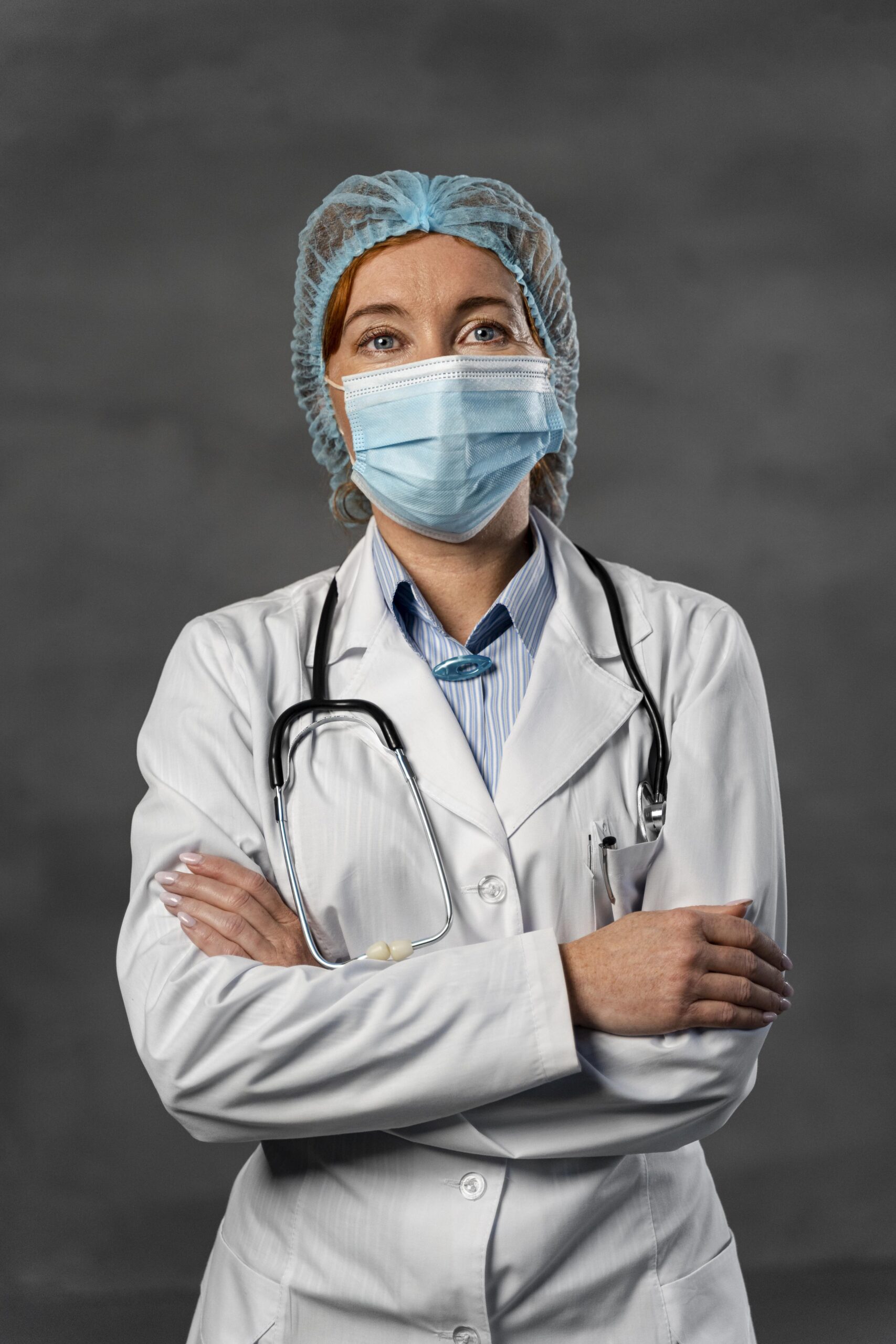 front-view-female-doctor-with-medical-mask-hairnet-posing-with-arms-crossed