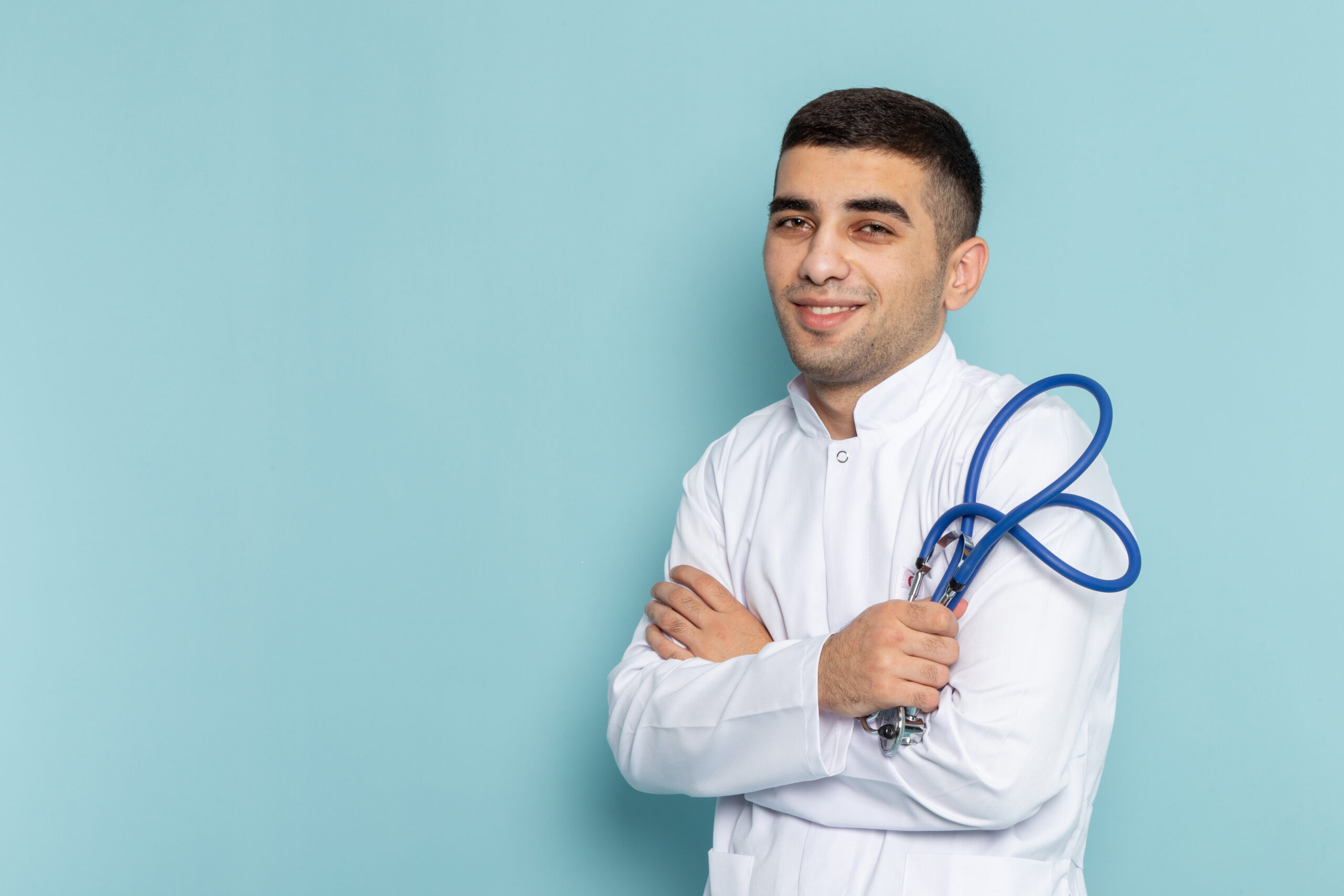 front-view-young-male-doctor-white-suit-with-blue-stethoscope-posing-smiling